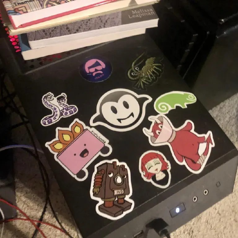 Black PC tower with assorted cartoonish stickers. 