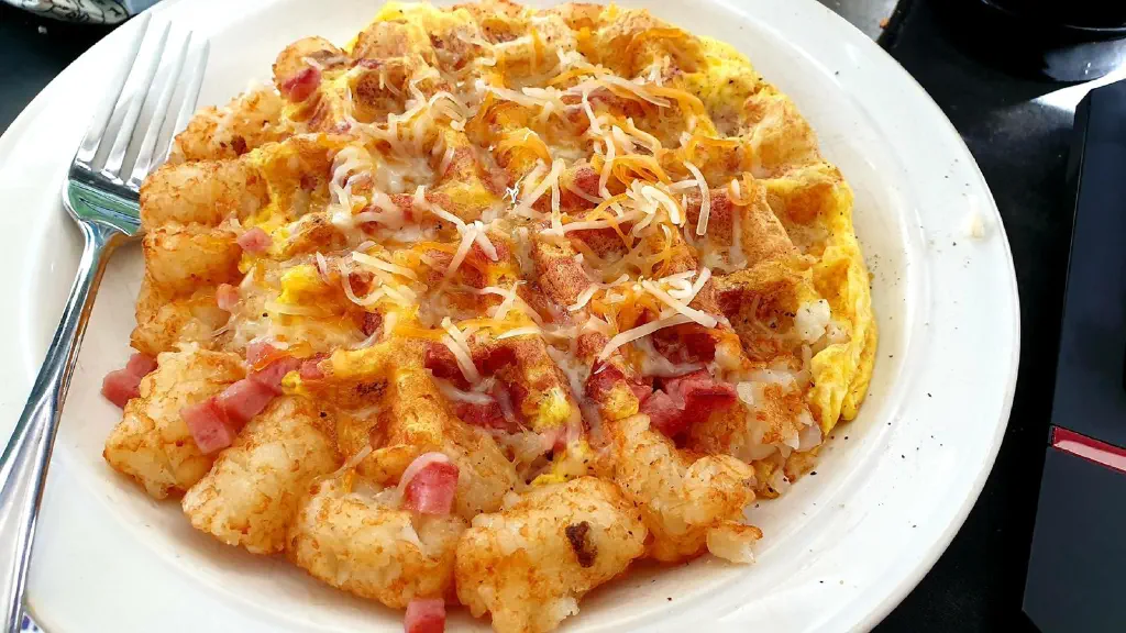 Half waffle half tater tots with cheese and chopped ham