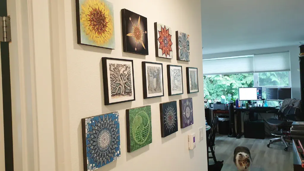 Wall decorated with tiles, each tile printed with one of our drawings; small dog walking in background