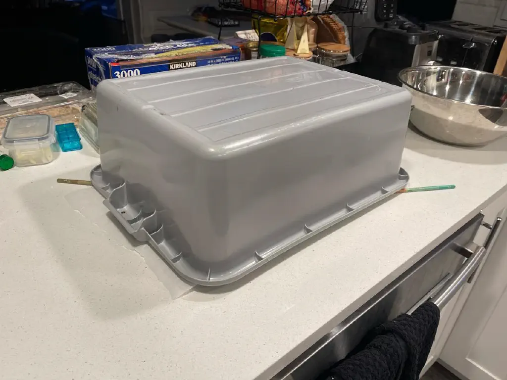 An upside down bus tub on a kitchen counter. 