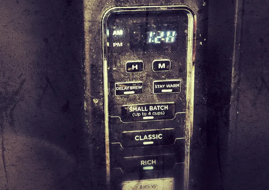 Detail of home coffee maker; its digital clock elements have worn out so that the current time is no longer legible as coherent digits