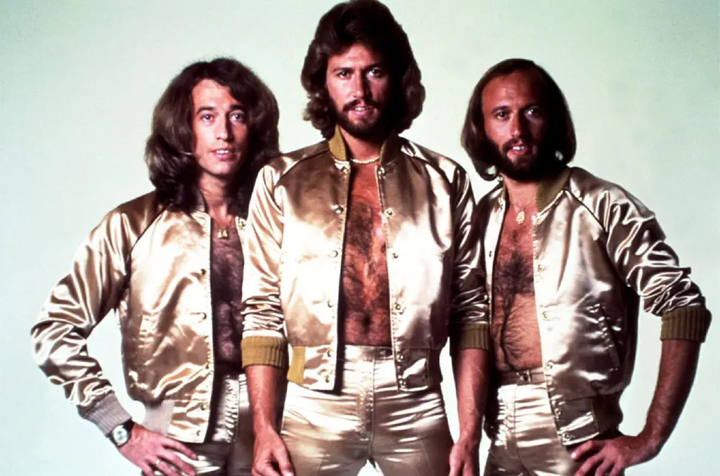 The Bee Gees at their popular peak, resplendent in reflective outfits, jackets open to reveal a 1970s-appropriate amount of body hair