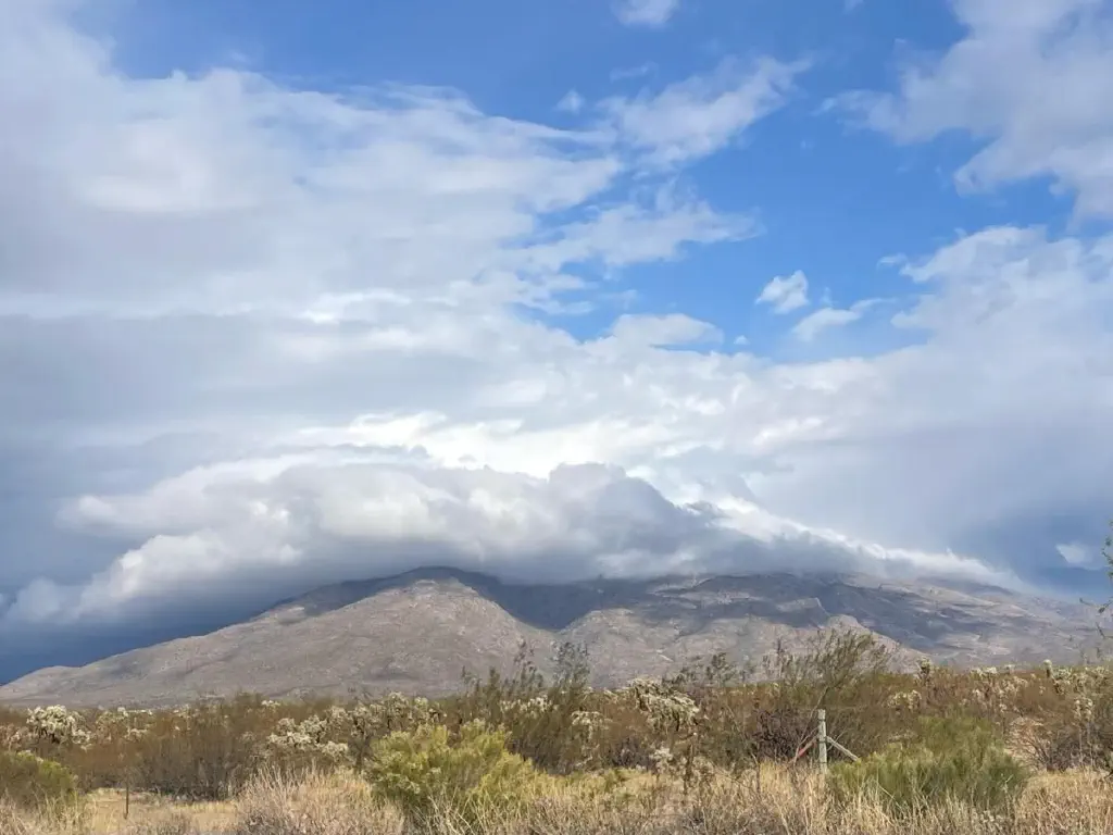 Mountain partly covered with clouds so low they are visibly following its slopes