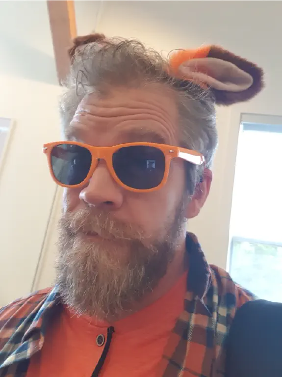 selfie of bearded dude wearing orange, including orange shades and cat-fox ears