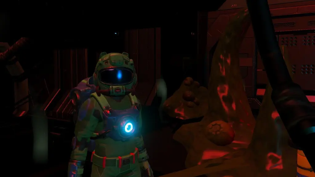 no man&rsquo;s sky screenshot with protagonist looking at camera while in a dark room surrounded by pulsing egg sacks.