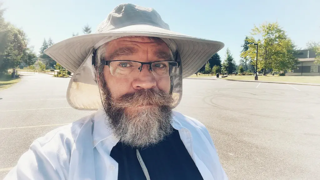 Beard dude out in sunshine, wearing a wide brimmed floppy hat