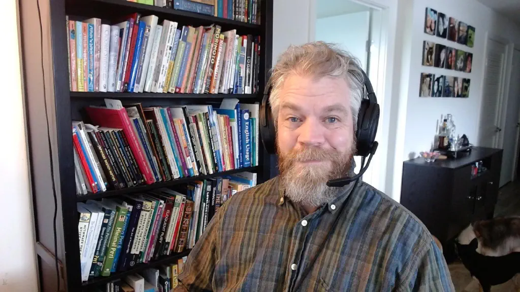 selfie of beardy dude wearing headset. Small dogs visible in background.