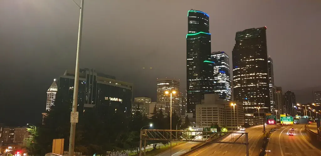 Nighttime Seattle skyline with clouds lit by city