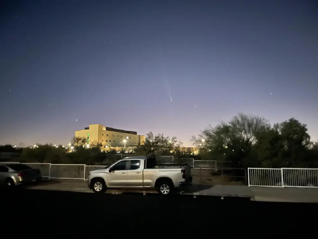 Pinpoint of comet and long streak of its tail are just visible in darkening dusk
