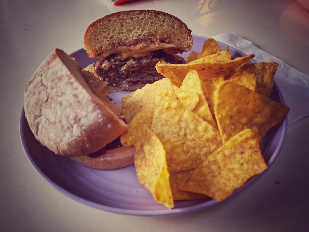 Photo of burger with Doritos on the side