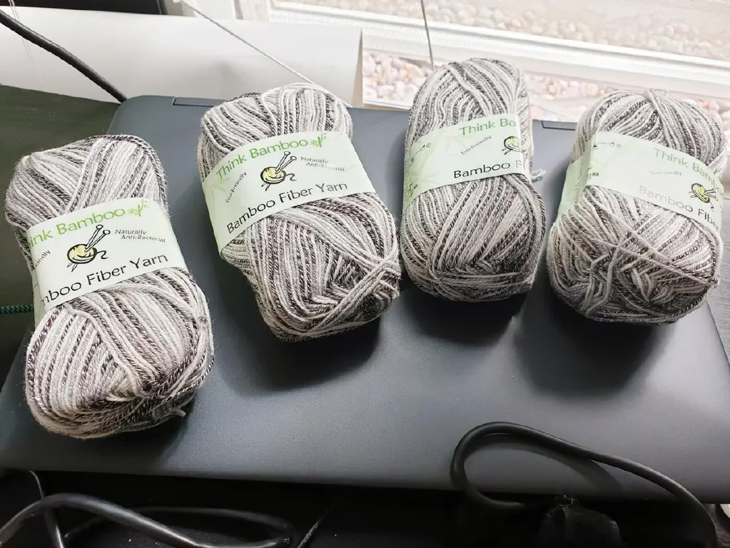 Four skeins of Think Bamboo brand sock yarn, multicolored in warm greys