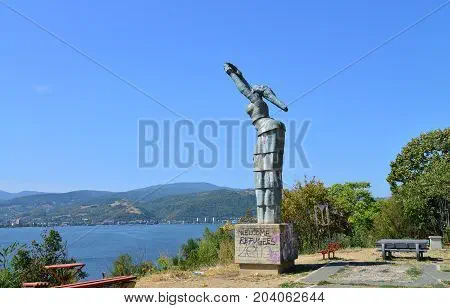 Stock photo of Danubia statue via Bigstock; graffiti at base says “WELCOME REFUGEES”