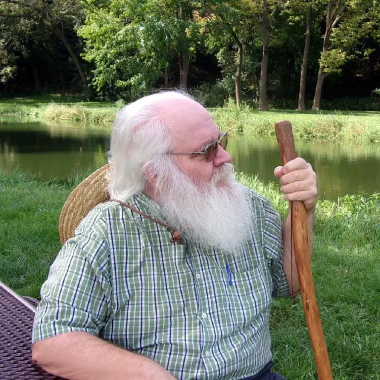 Older bearded man with walking stick