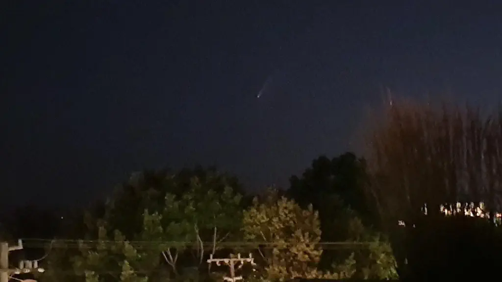 Visible comet tail over treetops and telephone poles