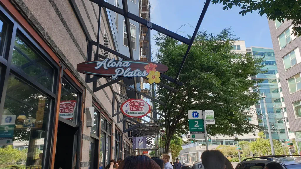 Looking at restaurant signs above a long line of people on the sidewalk