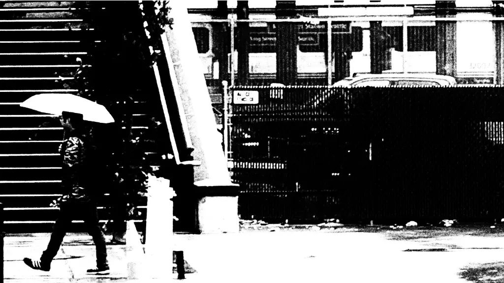 black and white pic of person walking with umbrella