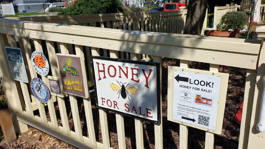 Home fence with signs promoting honey for sale