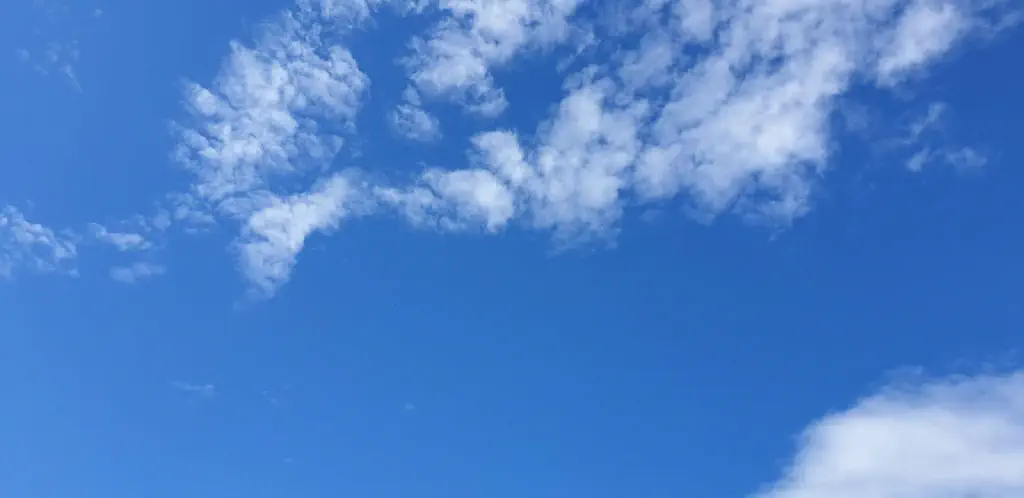 photo of blue sky with light fluffy clouds