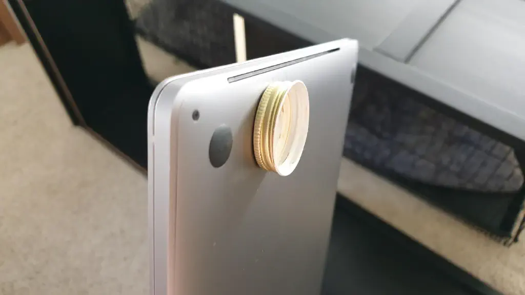 Bottle cap magnetically attached to bottom of MacBook pro