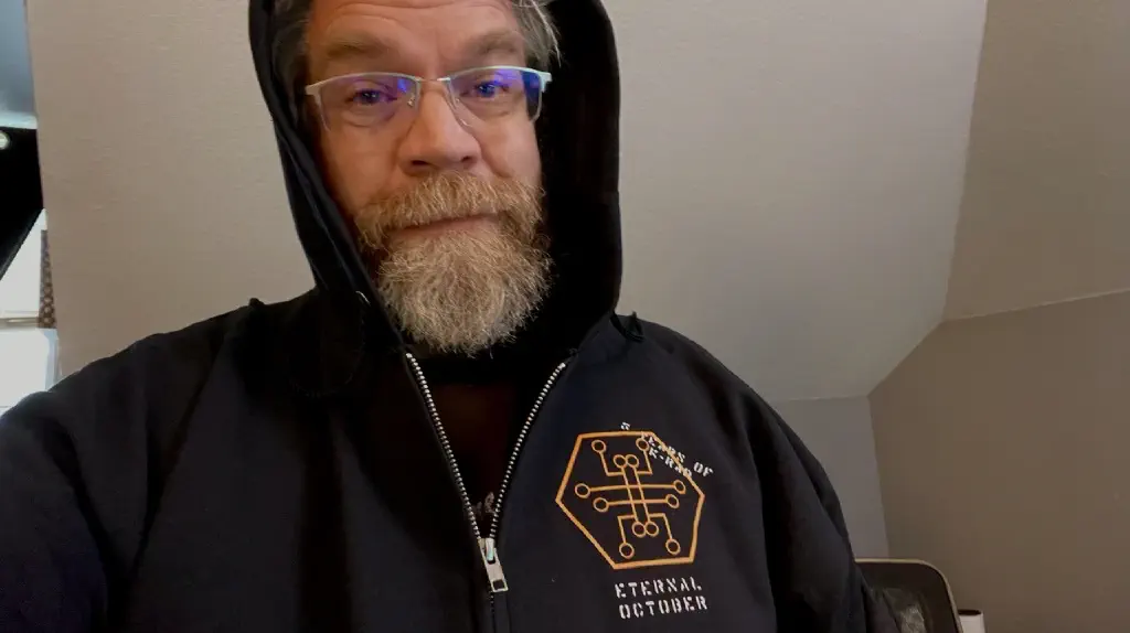 Tired beardy dude in glasses wears hoodie that has site logo with “Eternal October” text