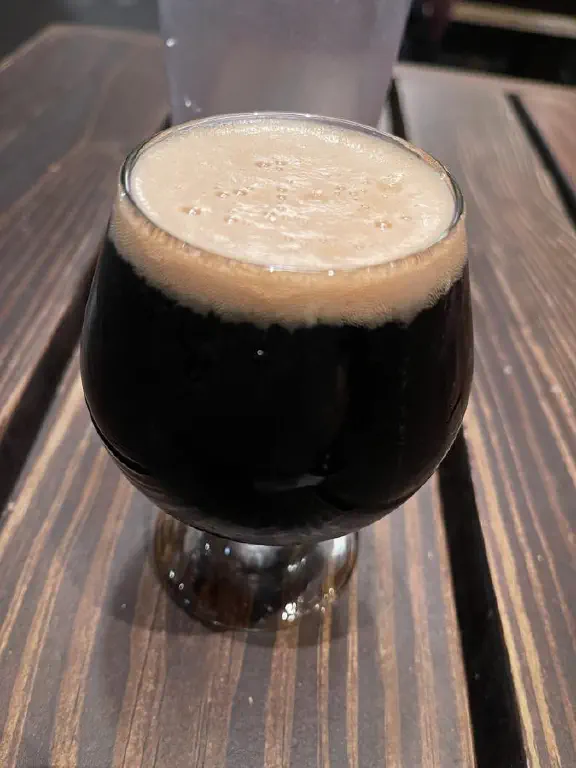 A very small glass of very dark beer