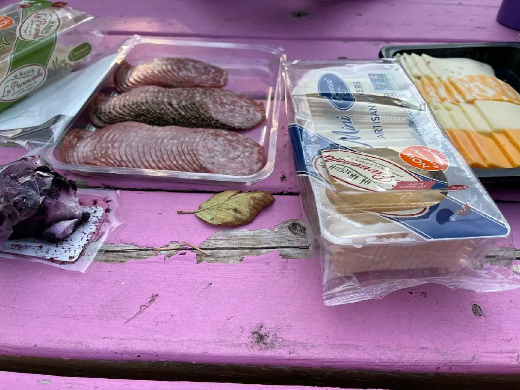 Pink picnic table with crackers, cheese, and meat