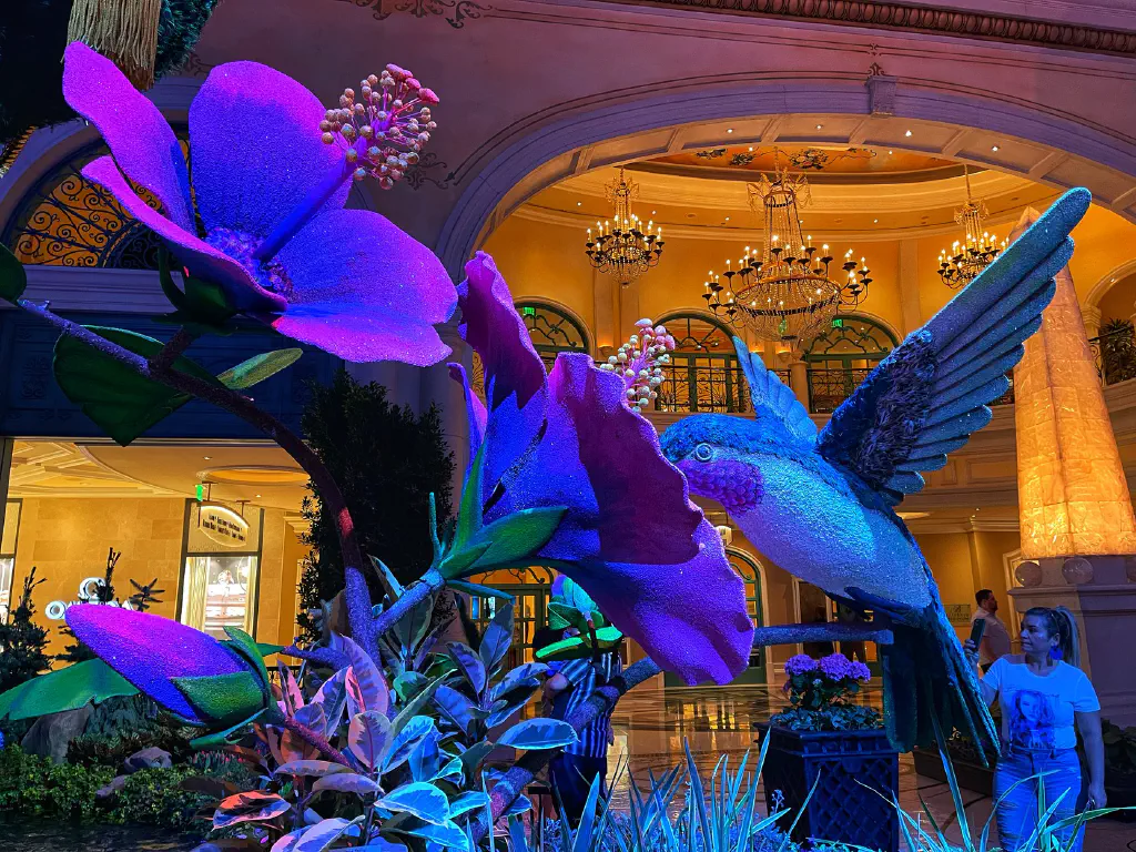Sculpture of giant hummingbird checking out sculpture of giant flowers