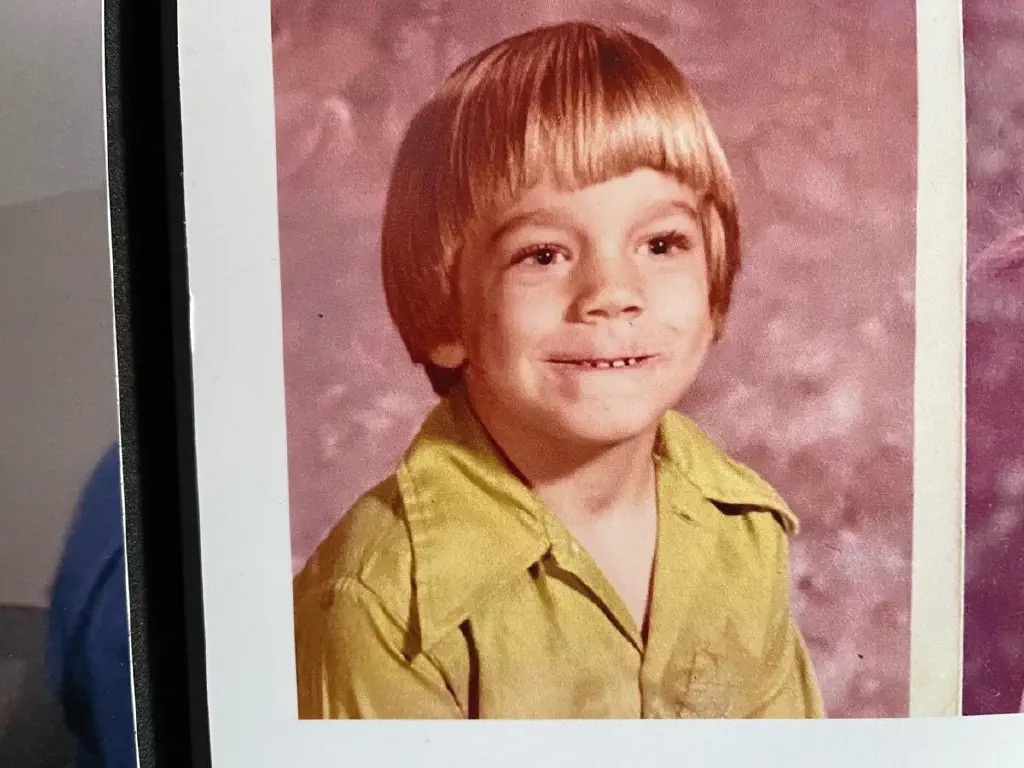 Photo of a 7 year old blond boy with a weird grimace smile