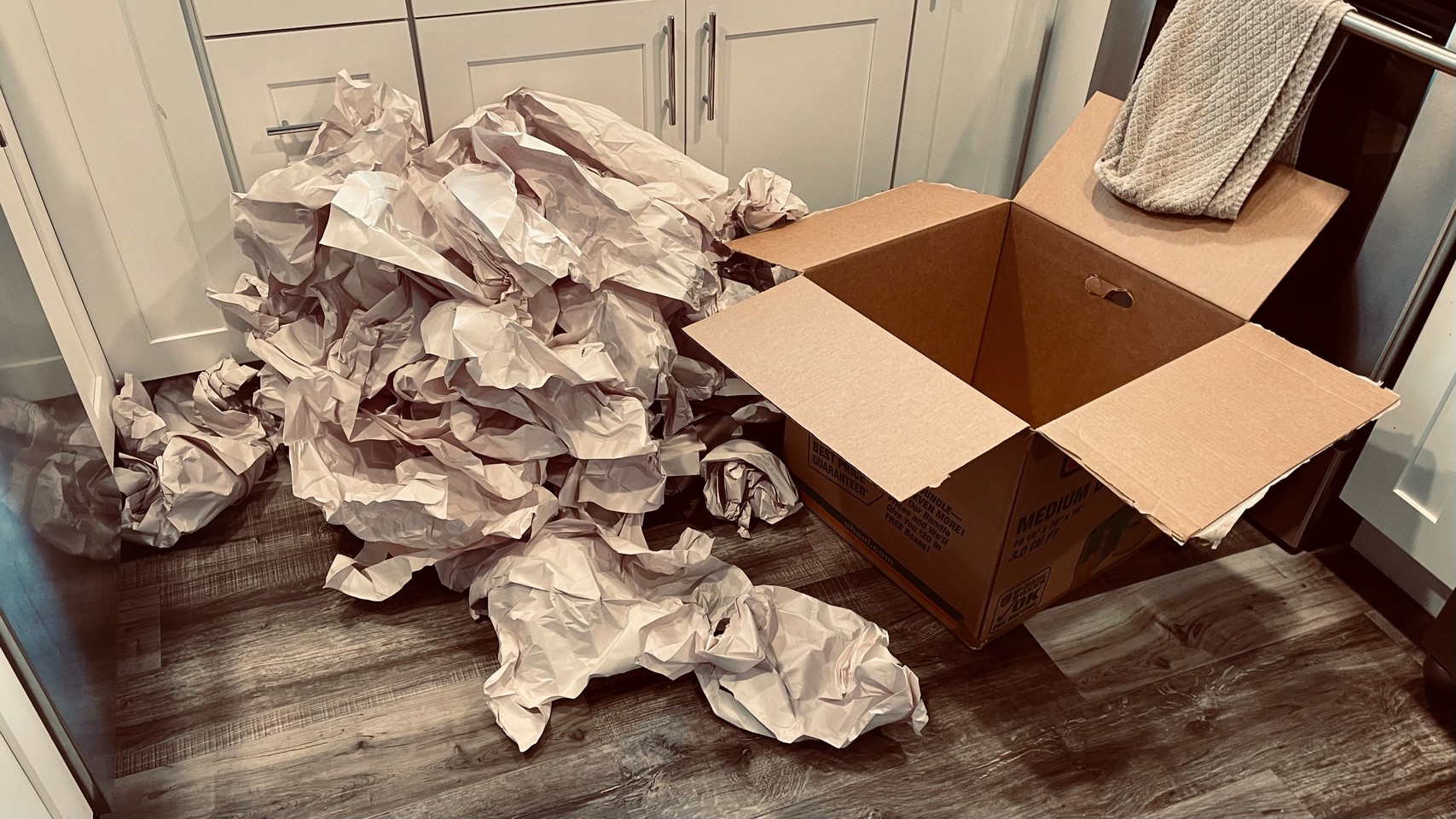 Huge pile of wadded-up paper next to an empty moving box