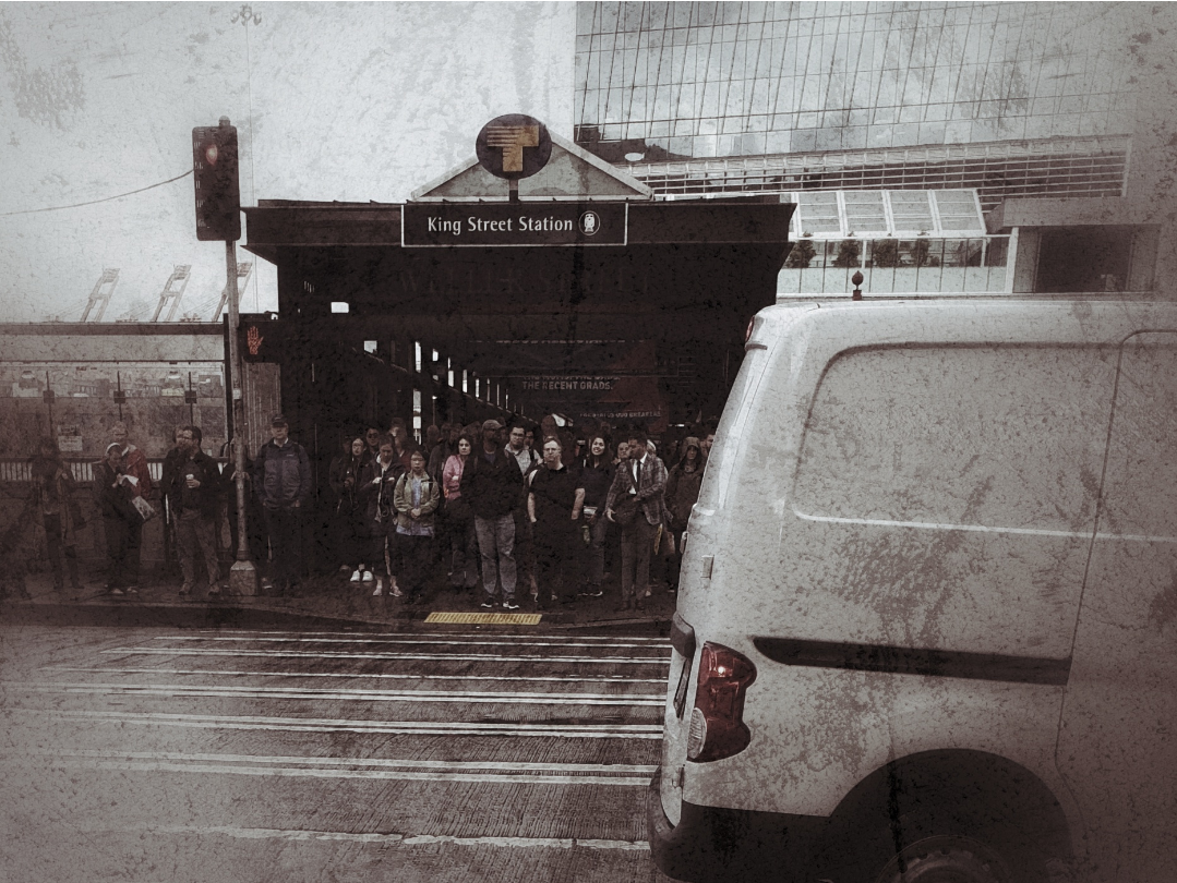 crowd of people waiting to cross the street