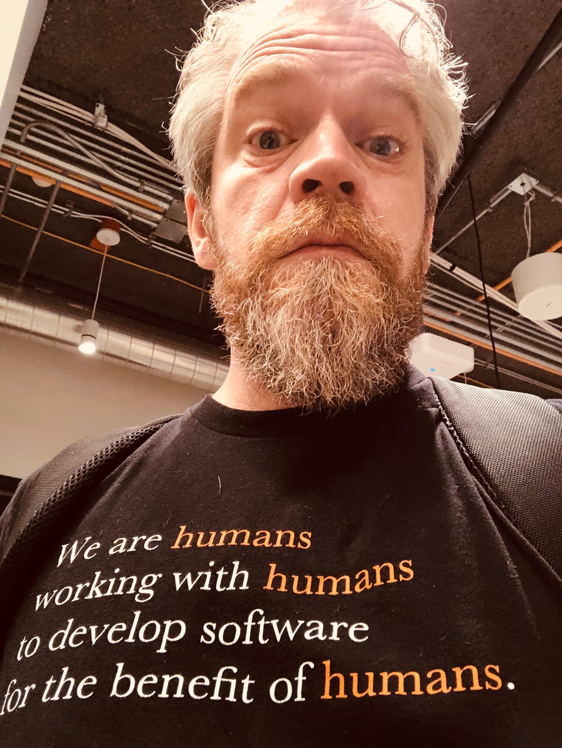 Tee shirt reads “We are humans working with humans to develop software for the benefit of humans.”