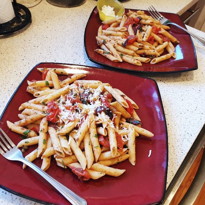 two plates of puttanesca side by side