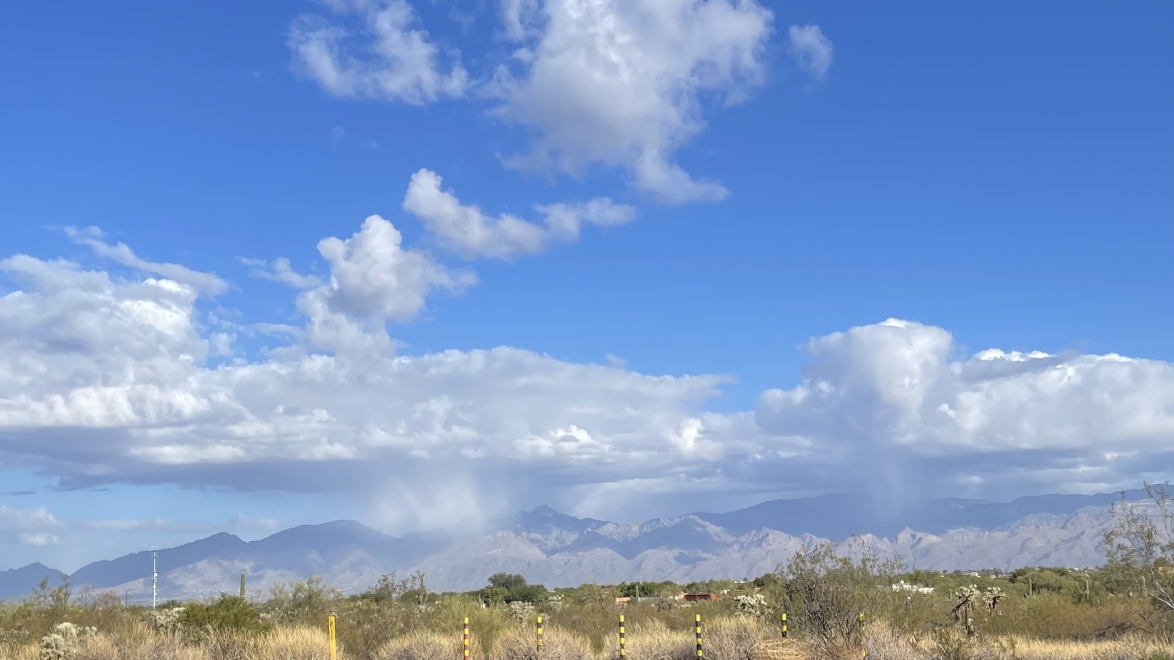 Clouds visibly dumping precipitation on the Santa Catalina mountains