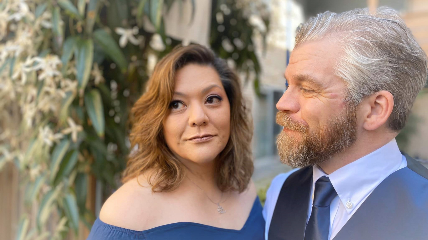 well-dressed beardy dude looking adoringly at well-dressed woman